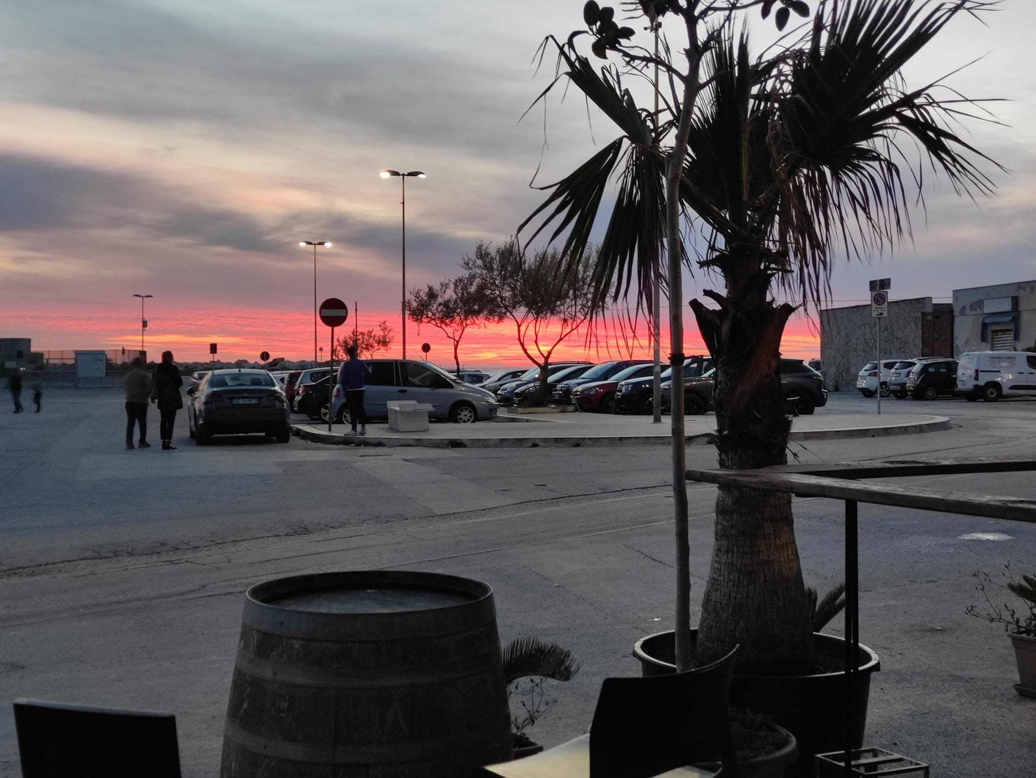 Il cielo rosa e arancio al tramonto, fotografato dai tavolini esterni del Nettuno a Trapani.